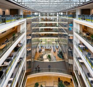 Moderne, open kantoorgebouw aan de Laan van Langerhuize met meerdere verdiepingen en glazen wanden rondom een centrale atriumruimte.